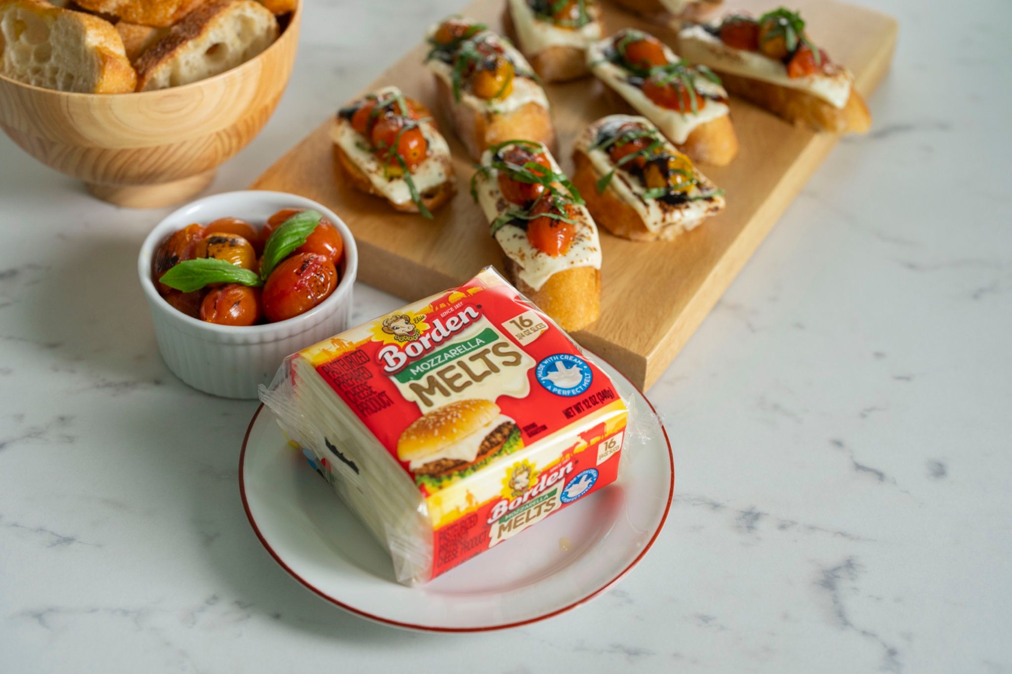 Empaque de queso Borden Melts junto a crostini con tomates