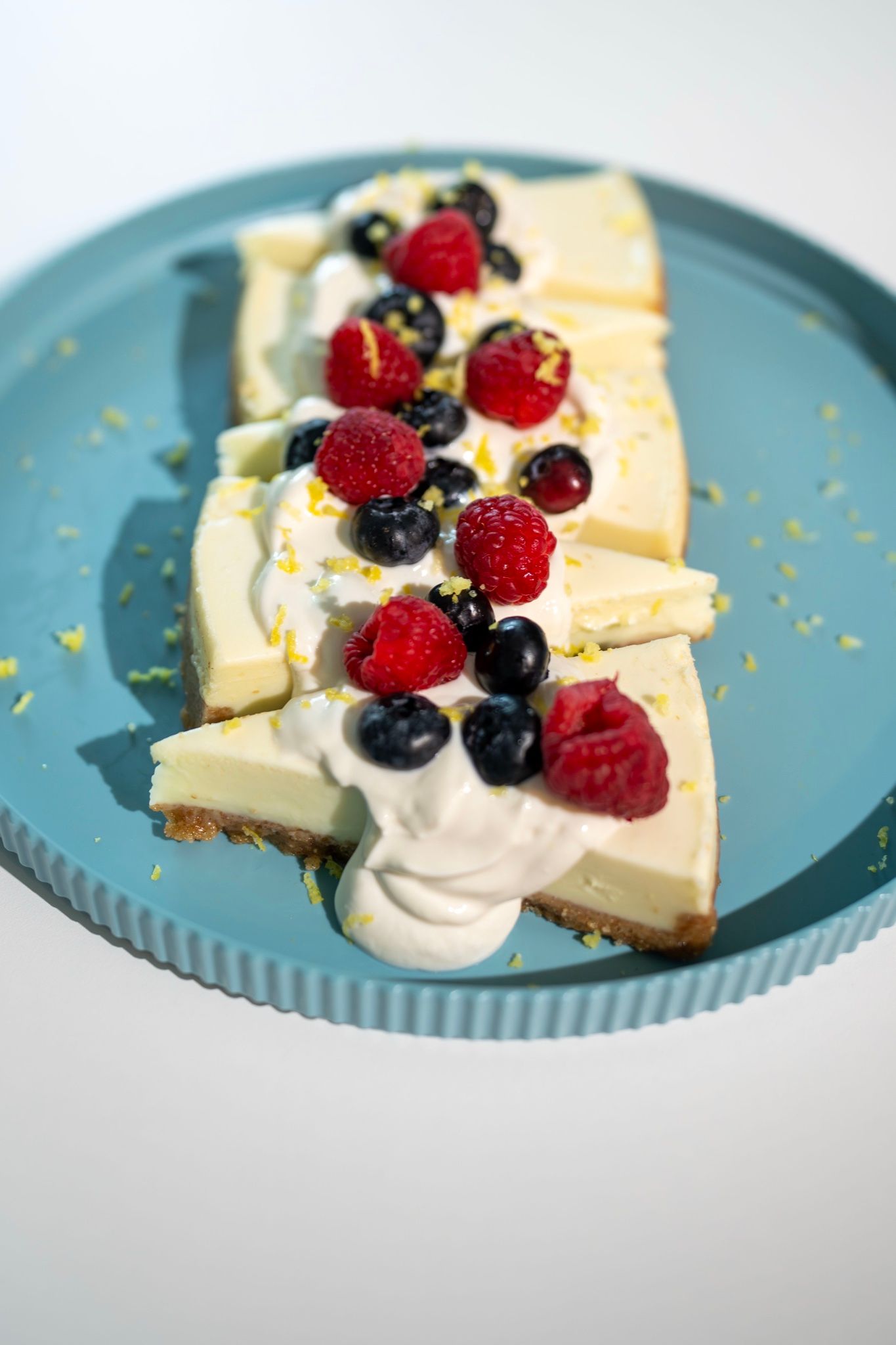Cheesecake con frutas rojas en plato azul