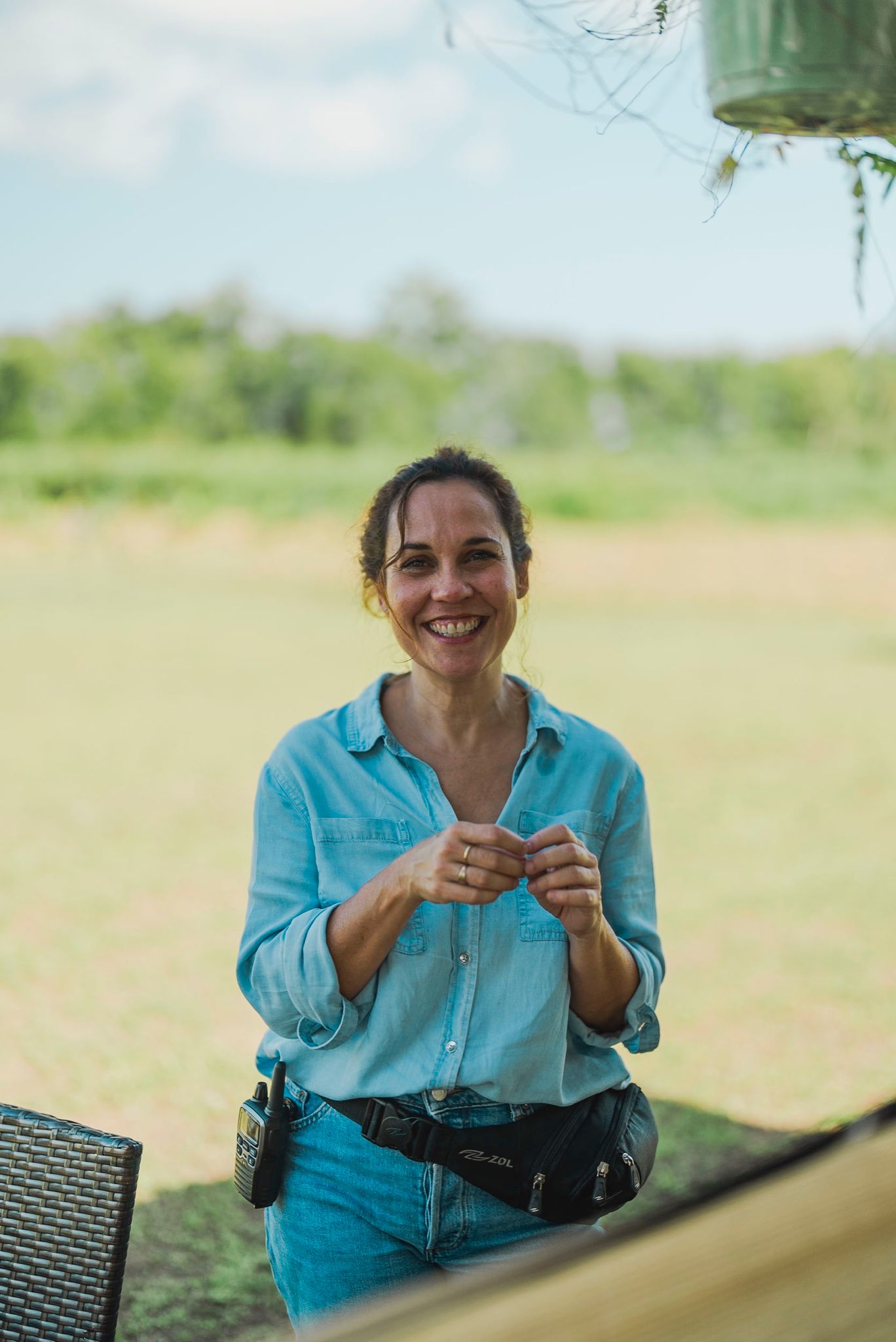Productora sonriendo con el arnés de cámara en una finca
