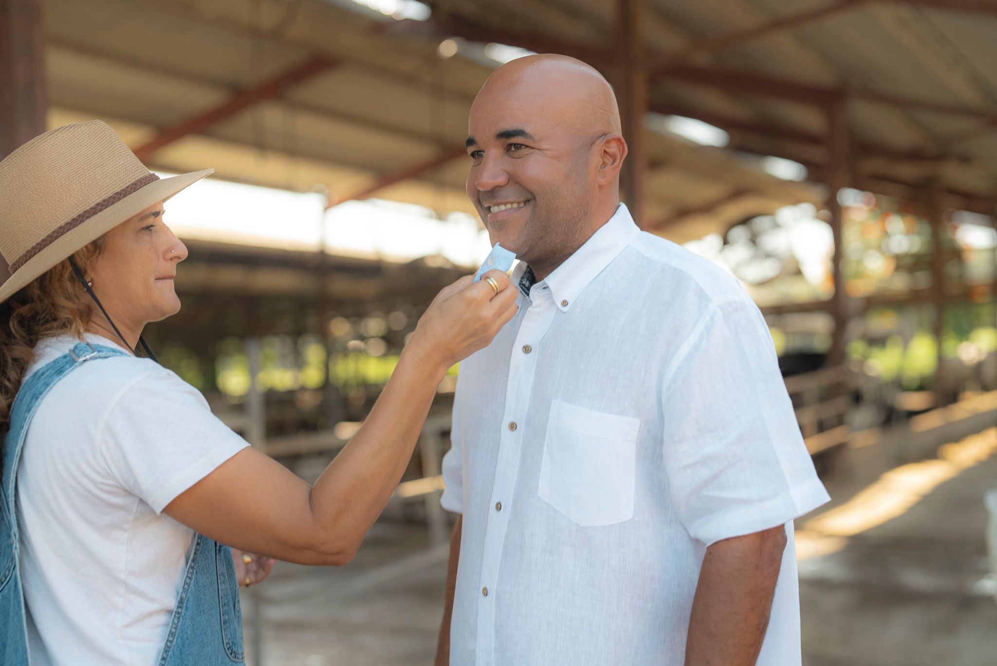 Retoque de maquillaje a un entrevistado sonriente en un granero